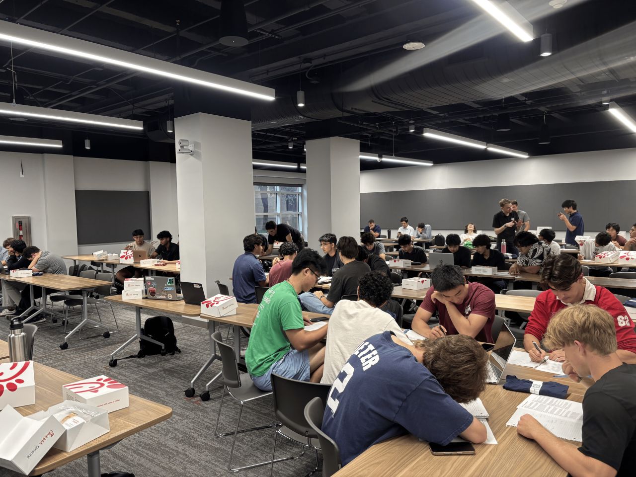 Student teams working together at tables during the Citadel and Citadel Securities Quantitative Challenge